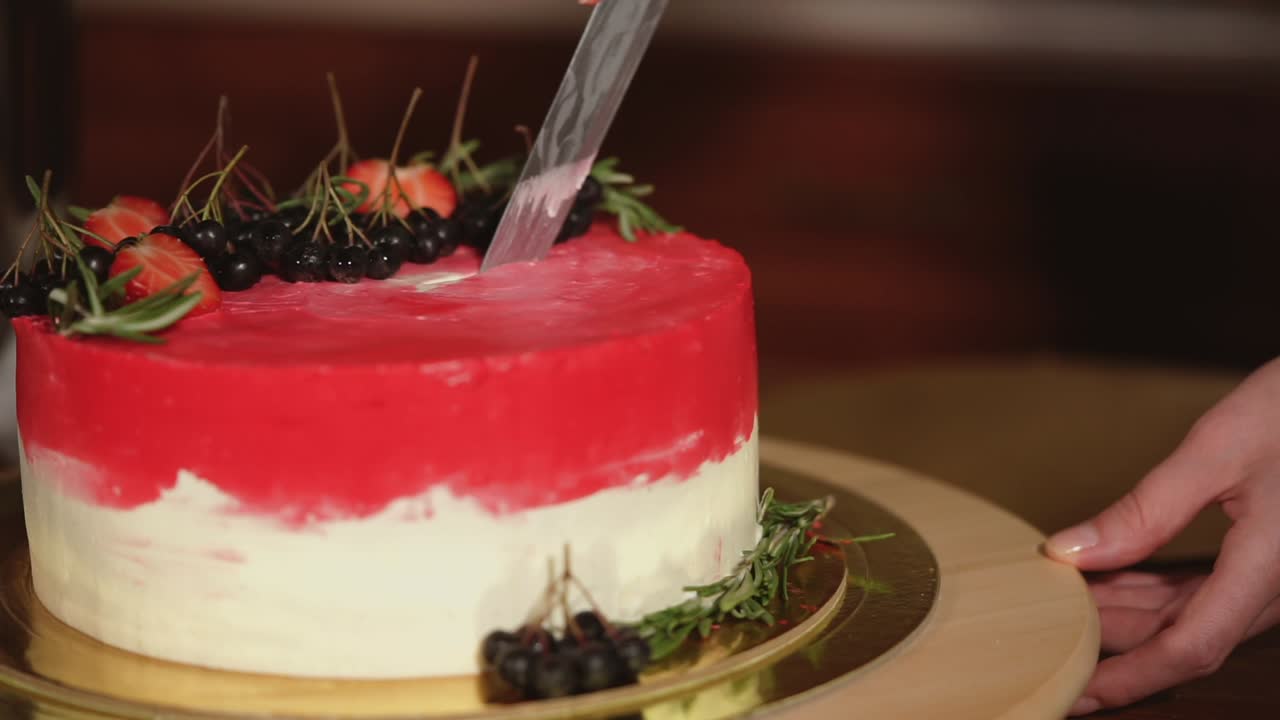 Tagliare una bellissima torta Red Velvet con fragole e frutti di bosco