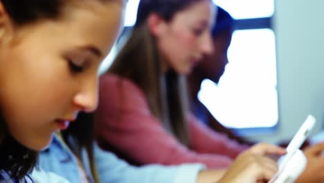 estudiantes que usan tabletas digitales en el aula