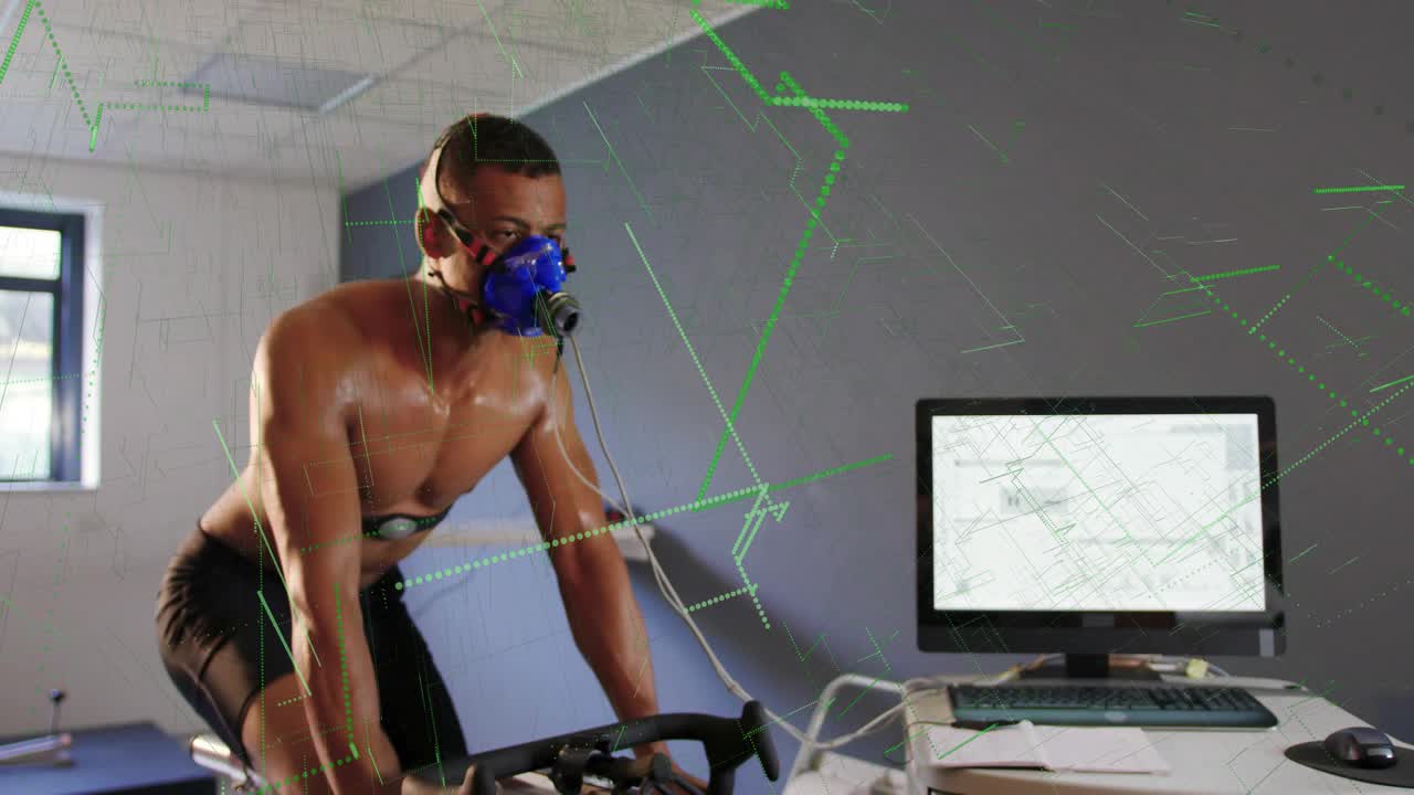 Male cyclist pedaling bike in fitness lab, PC capturing data, green graphs showing mask sensors