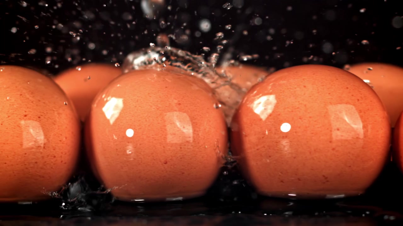 Acqua che schizza al rallentatore su uova fresche marroni