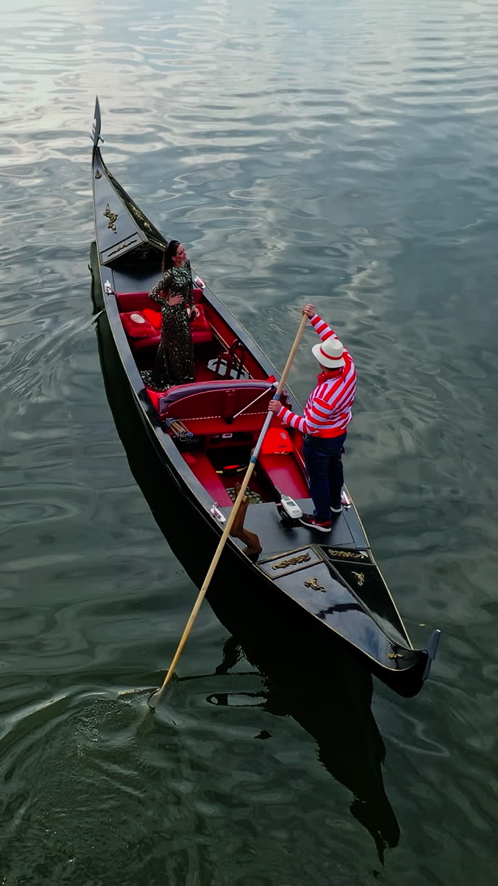 Walk on gondola in city. Gondola going down on river carrying people on board