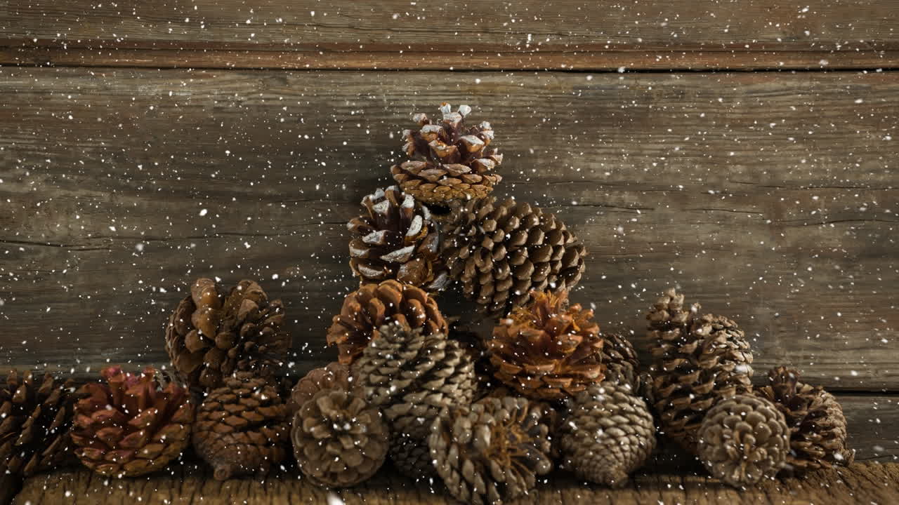 nieve cayendo sobre múltiples conos de pino en la superficie de madera