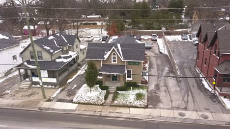 exterior drone shot of a small house in the winter