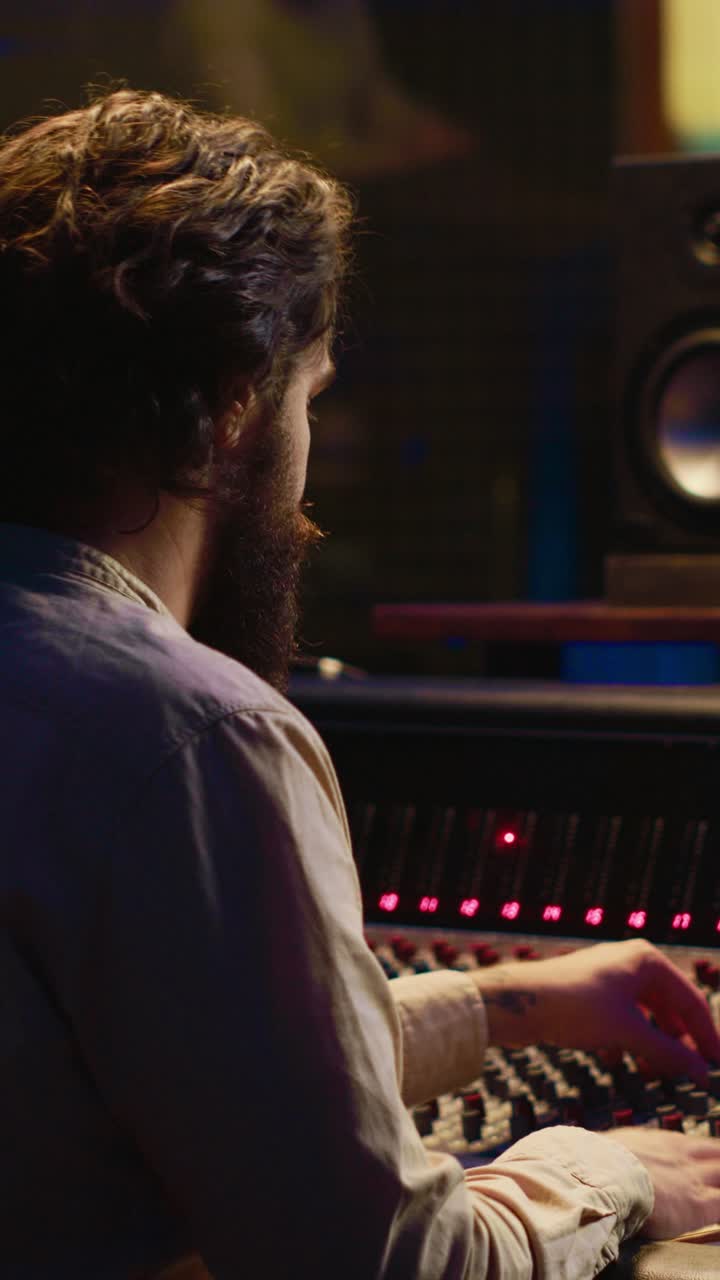 Sound Engineer Working on Mixing Console in Recording Studio