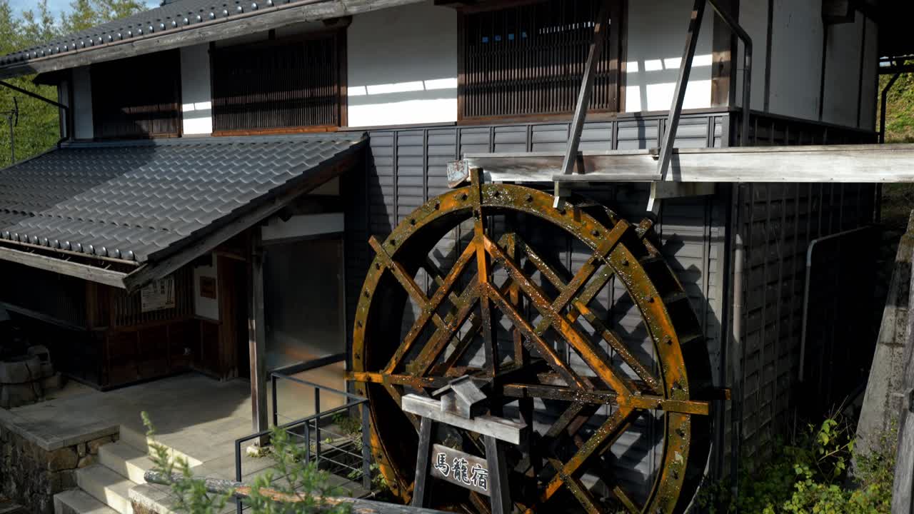 A scenic view of a traditional water mill along the historic Nakasendo Trail in Magome, Japan. This well-preserved water mill reflects the rich cultural heritage of the area.