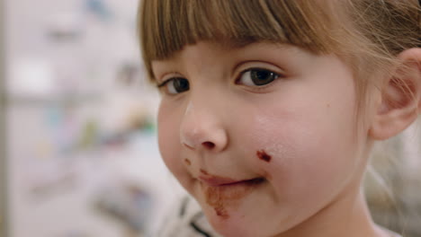 niña feliz con las manos cubiertas de chocolate lamiendo los dedos divirtiéndose horneando en la cocina niño travieso jugando disfrutando de la infancia