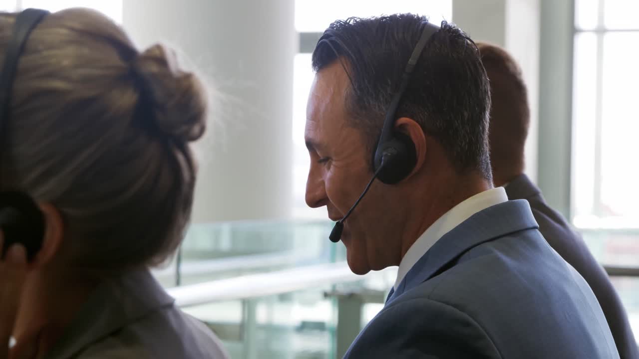 Profissionais de negócios usando fones de ouvido em um escritório moderno