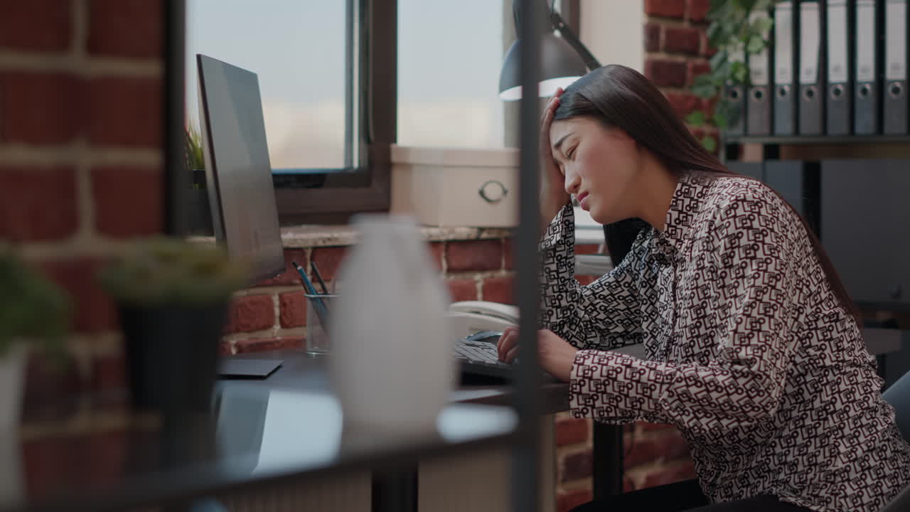 Woman with migraine trying to work on computer