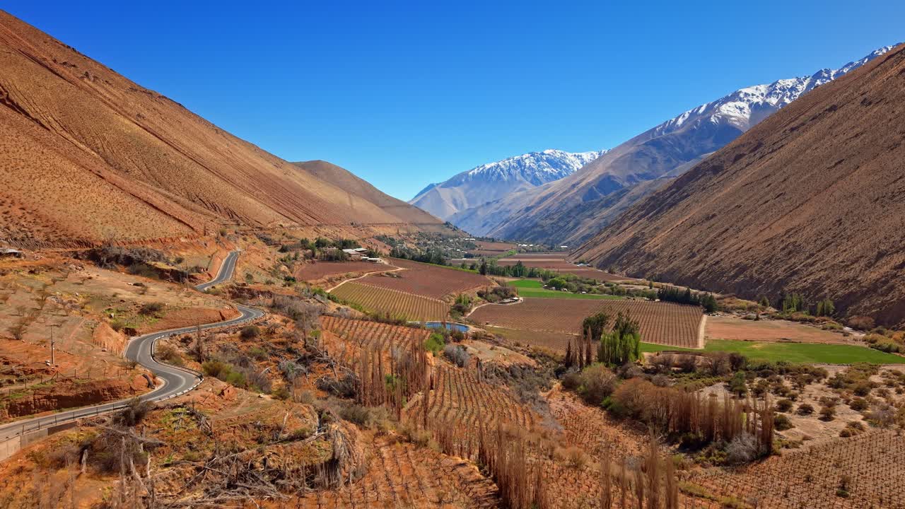Aerial flight over the Elqui Valley with arid mountains and vineyards for Chilean pisco on a sunny day