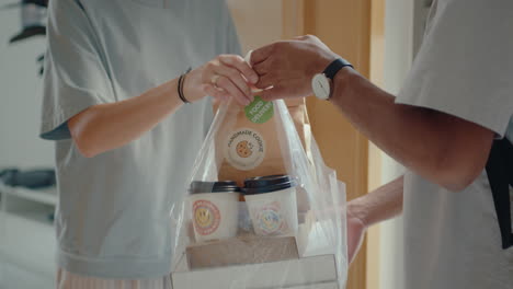 woman receiving bag with food from delivery guy