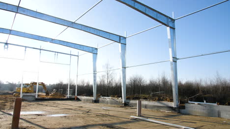 construction site with foundations pillars made of alternative eco friendly sustainable materials, under sunny dat in countryside with yellow crane excavator working in background