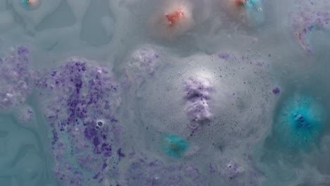 dissolved bath bomb in water close-up. soap foam bubbles. decorative cosmetic products for bathroom concept. liquid boiling texture. relaxation and skin care