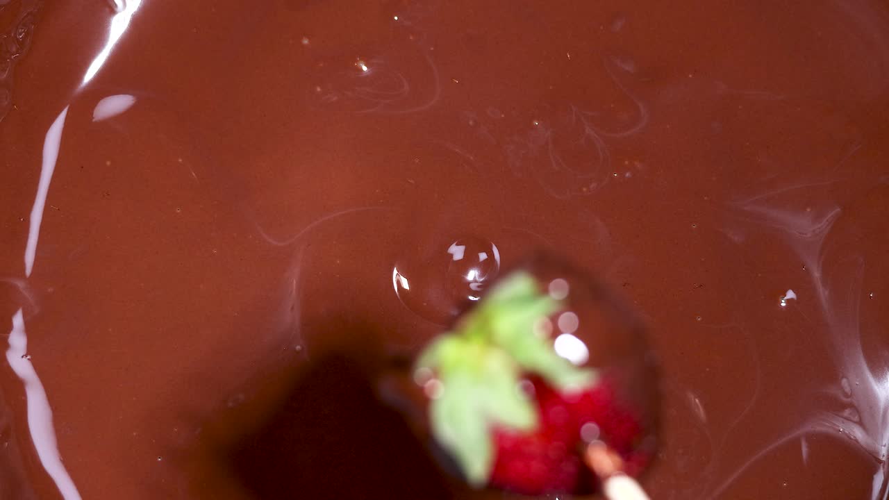 녹은 초콜릿 에 딸기 를 담그고 있는 것