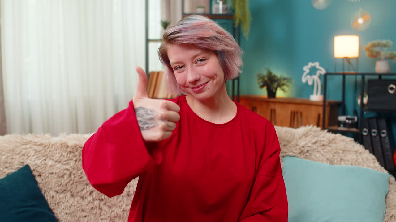 Happy woman showing thumbs up gesture positive approval agreement good feedback smiling cheerfully