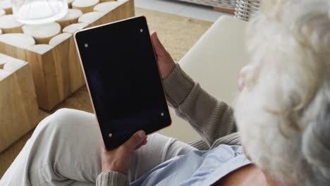 mujer mayor afroamericana haciendo una videollamada en una tableta digital con espacio de copia en casa