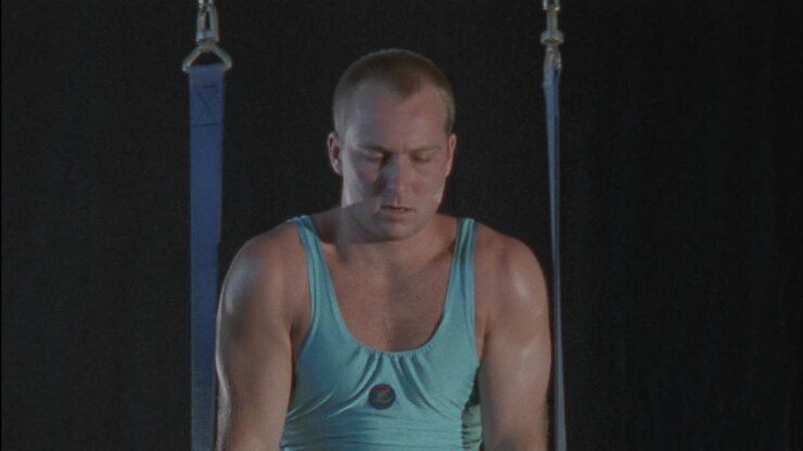 A man does a gymnastics workout on rings