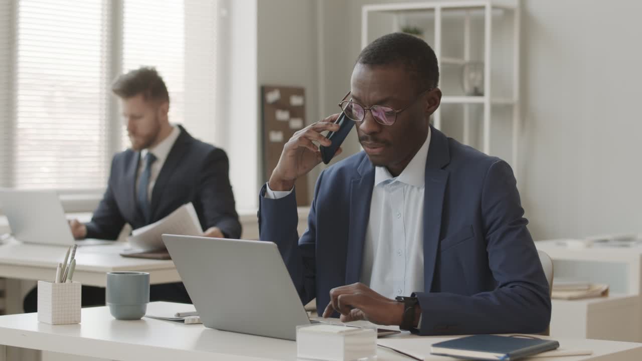 Trader afroamericano che parla con un investitore al telefono