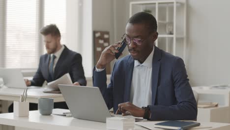 african american trader talking with investor on smartphone