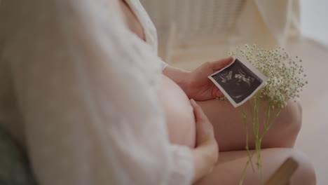 pregnant woman admiring ultrasound photo close-up