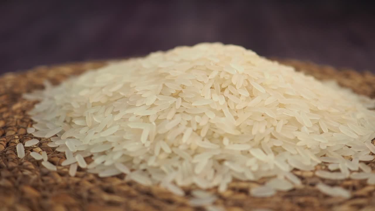 Primo piano di chicchi di riso bianco su una superficie intrecciata
