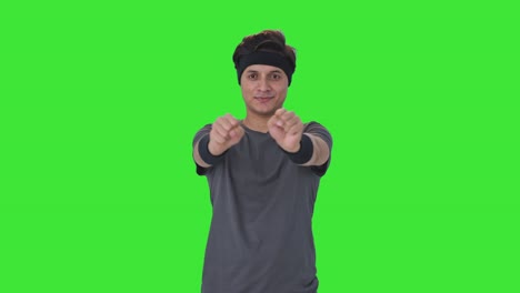 hombre indio feliz haciendo ejercicio de rotación de la muñeca pantalla verde