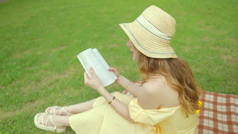 Caucasian-female-in-20th-reading-a-book-sitting-on-lawn