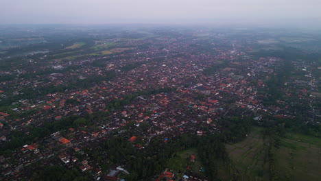 Drohnenaufnahme-Aus-Einem-Hohen-Winkel-über-Ubud-Auf-Bali-Am-Abend-Mit-Schmutzigem-Klima-In-Der-Luft---Überbevölkerung-Und-Schwebenden-Dämpfen-Am-Himmel