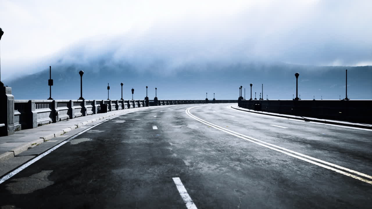 Smooth road curves under moody clouds near the mountain range