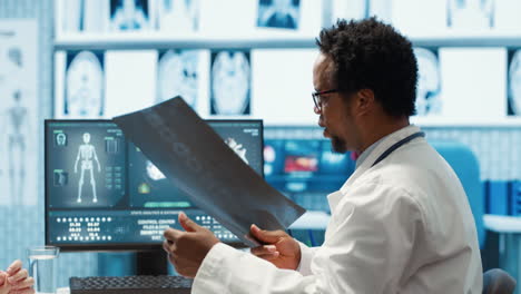 physician reviewing mri scan and x ray results with a patient in medical office