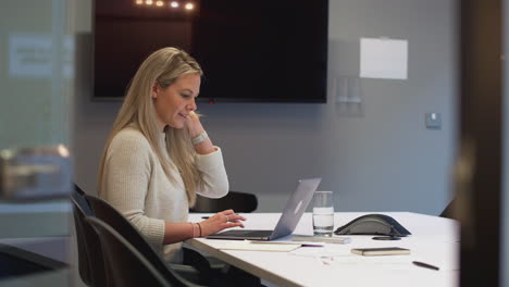 businesswoman working late in office meeting room using laptop
