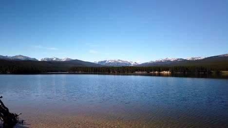 Zeitraffer-Des-Parkreservoirs-Im-Bighorn-National-Forest-An-Einem-Klaren-Sommertag-Mit-Schneebedeckten-Wolken-Im-Hintergrund