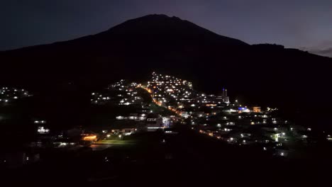 Vista-Aérea-Del-Hermoso-Pueblo-En-La-Ladera-De-La-Montaña-Por-La-Noche