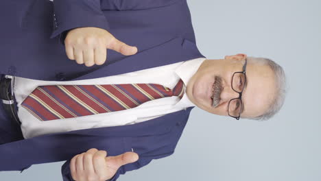 Vertical-video-of-Old-businessman-giving-positive-affirmation-looking-at-camera.