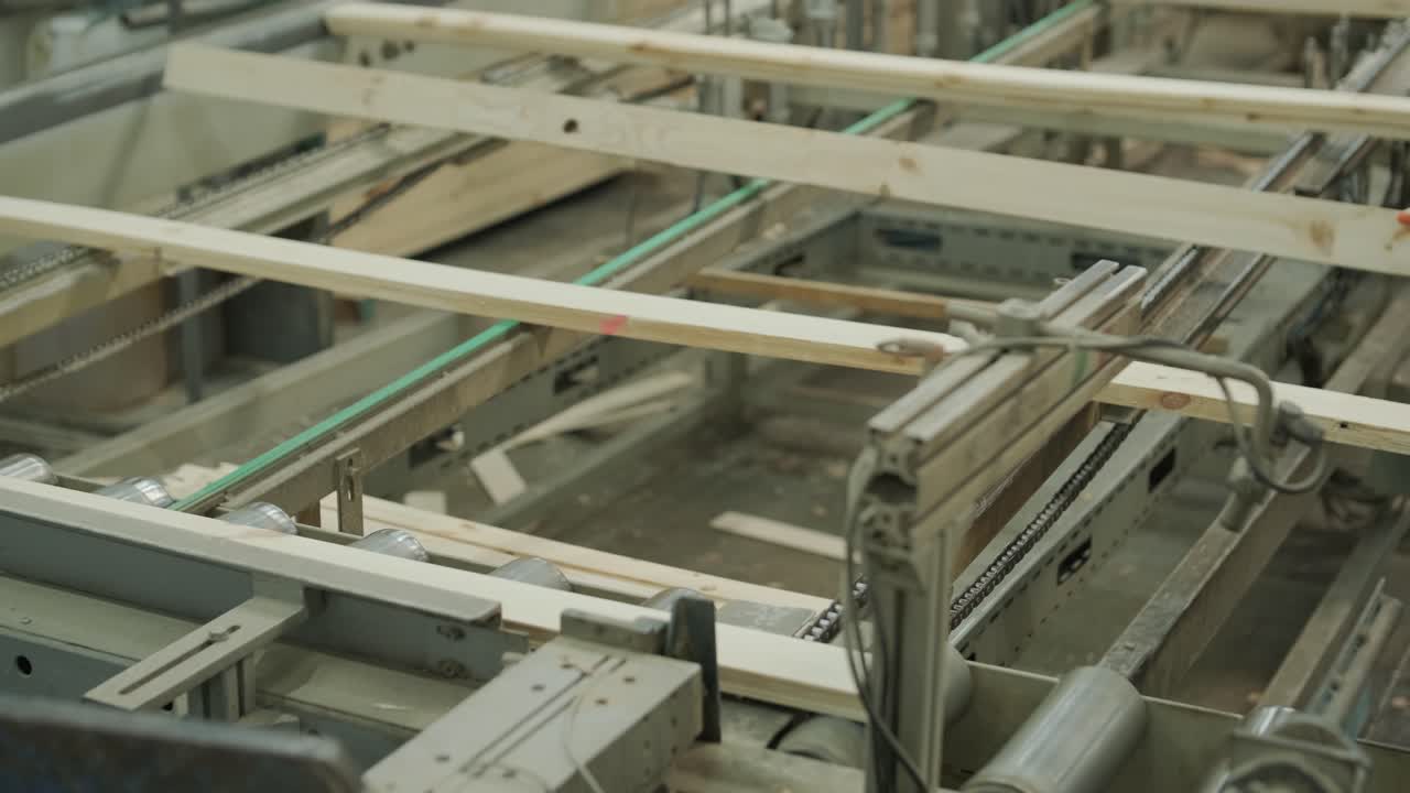 Assi di legno che si muovono su un nastro trasportatore automatizzato in fabbrica.