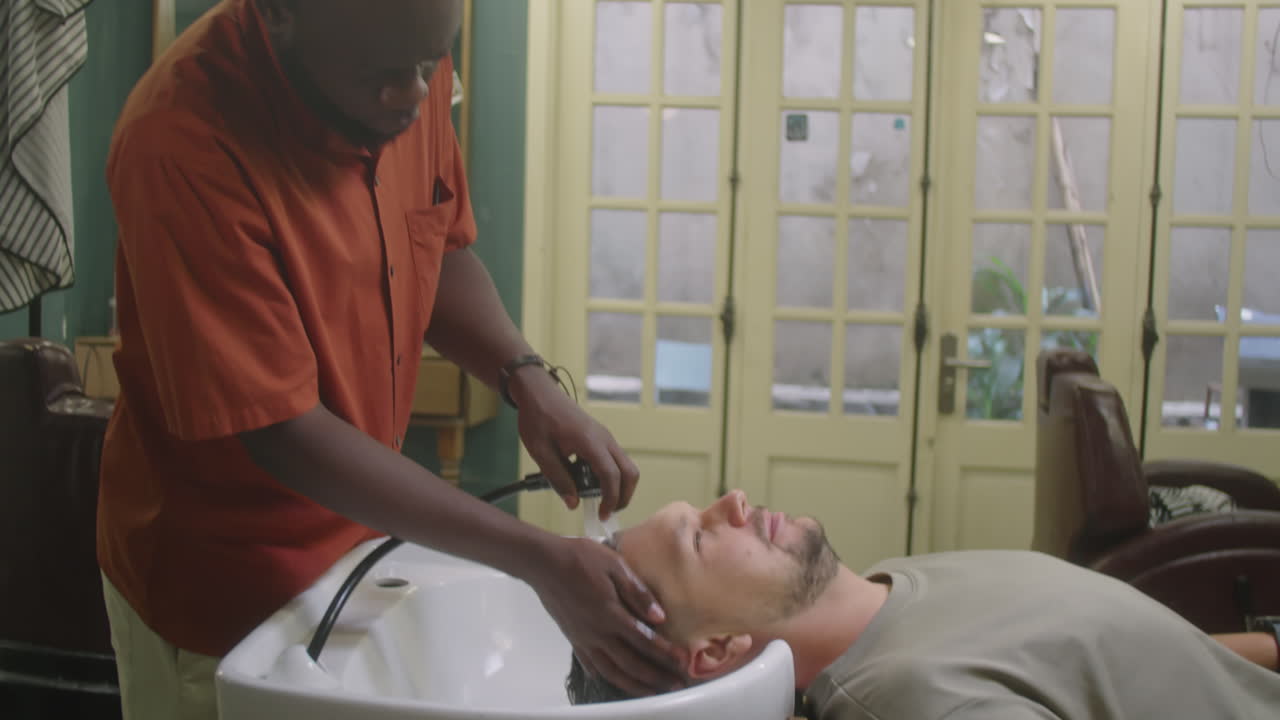 Barber Washing Hair of Male Client in Barbershop