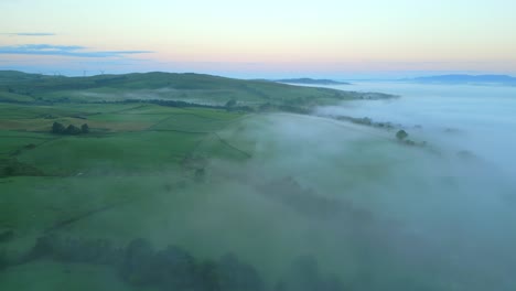 Volando-Sobre-Campos-De-Mosaico-Inglés-Con-Banco-De-Niebla-Brumosa-Al-Amanecer.