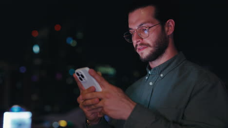 man using smartphone at night in the city