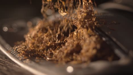 male hand collects tobacco from the tobacco pouch