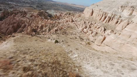 Fly-Over-Barren-Landscape-With-Rock-Formation-And-Cliffs-In-Cappadocia-Region,-Central-Turkey