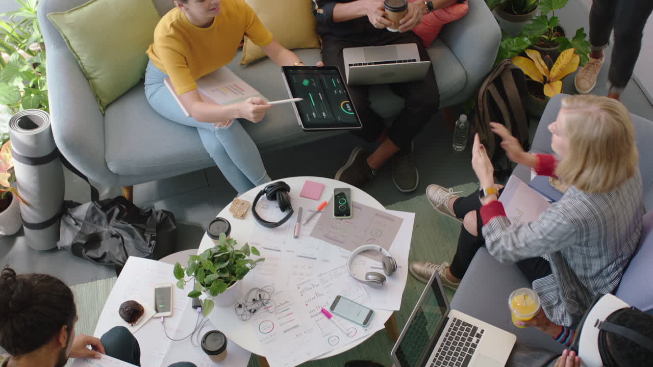 jóvenes ingenieros desarrollando software de aplicaciones de fitness utilizando tabletas digitales haciendo lluvia de ideas sobre soluciones de diseño compartiendo ideas en la reunión de la oficina de inicio vista superior
