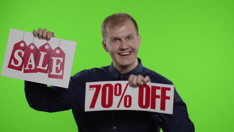 cheerful man showing sale word and showing up to 70 percent off inscription. black friday concept