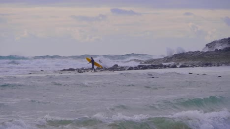 Surfers-With-Surfing-Board-Walking-In-The-Wavy-Ocean---Surfing-At-The-Beach-In-Crescent-Head,-New-South-Wales,-Australia---wide-shot