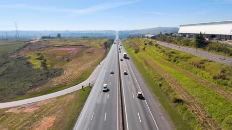 vista aérea de una autopista ocupada que atraviesa un paisaje rural con vehículos en movimiento - brasil