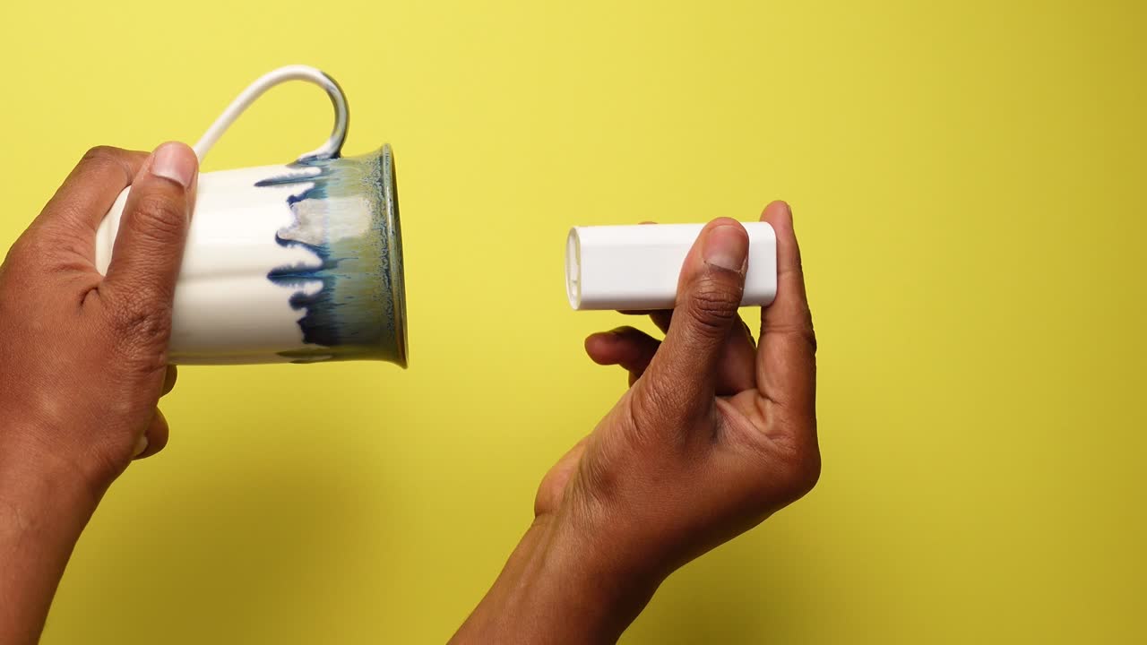 Hand Holding Mug and Tube