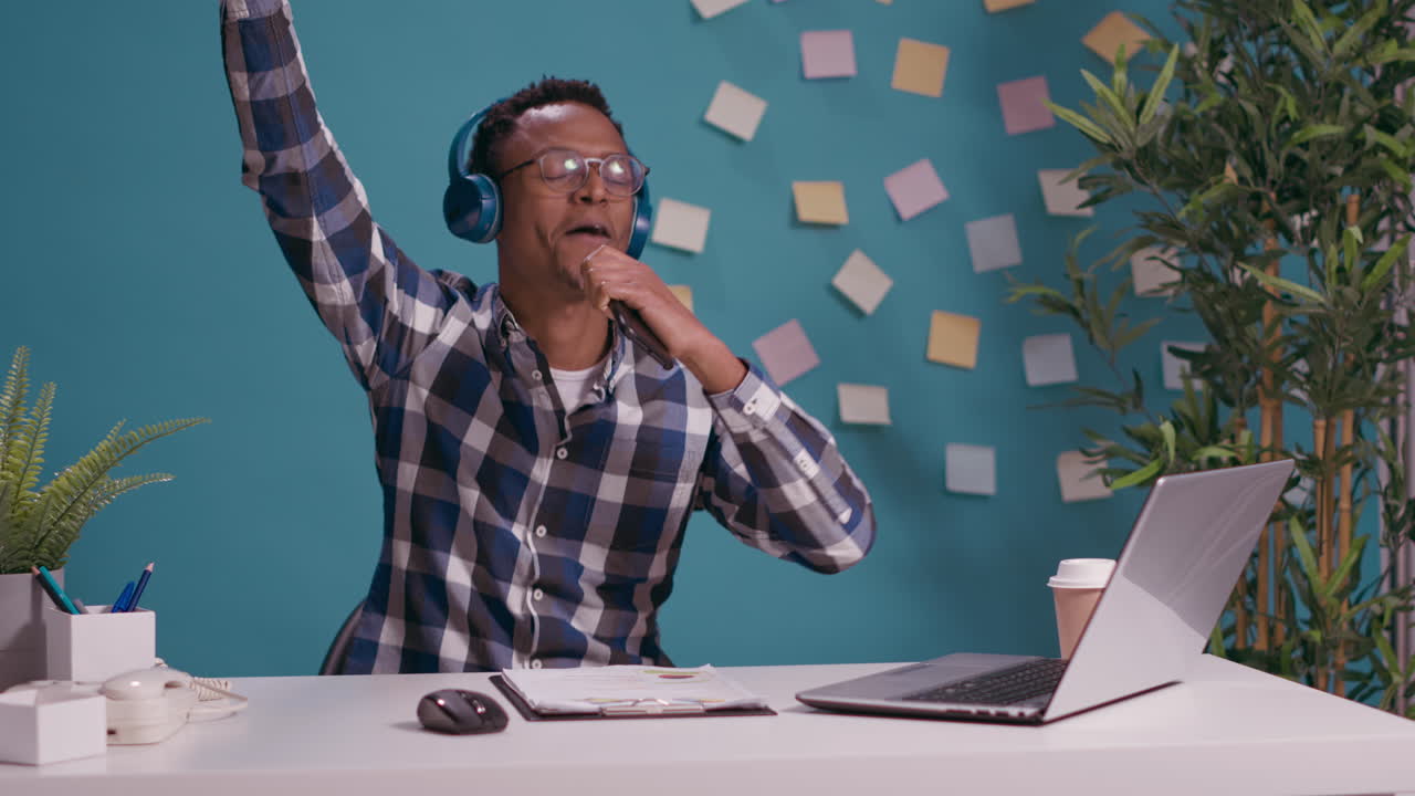 Happy man recording song and listening to music on headset