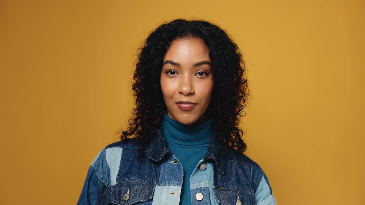 Portrait of a Smiling Woman with Curly Hair in Denim Jacket