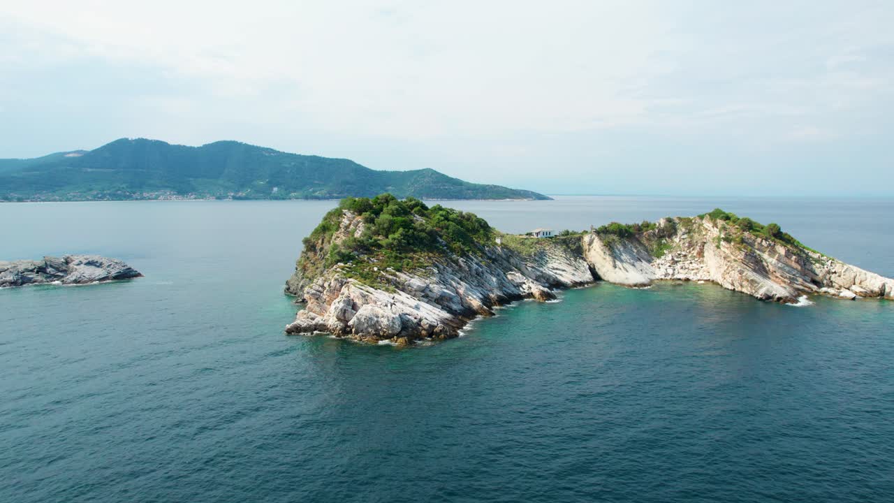 지중해 에 둘러싸인  ⁇ 색 교회 를 가진 그램보우사 섬 의 측면 항공 뷰, 날아다니는 새 들, 높은 산 정상, 푸른 식물성, 타소스, 그리스