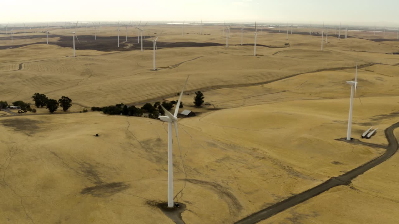 toma aérea de molinos de viento en un exuberante campo verde en las colinas de montezuma