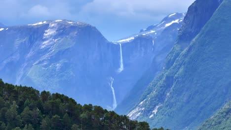 Die-Drohne-Zoomt-Heran-Und-Erhebt-Sich-Langsam-Hinter-Bergen,-Und-Mardalsfossen-In-Eikesdal-Kommt-In-Sicht