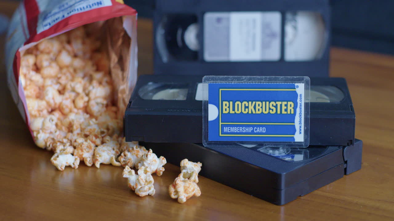 Wide Pan Right Shot of a Blockbuster Membership Card with VHS Tapes